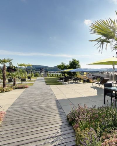 Restaurant Wil — Terrasse mit Palmen und Sonnenschirmen